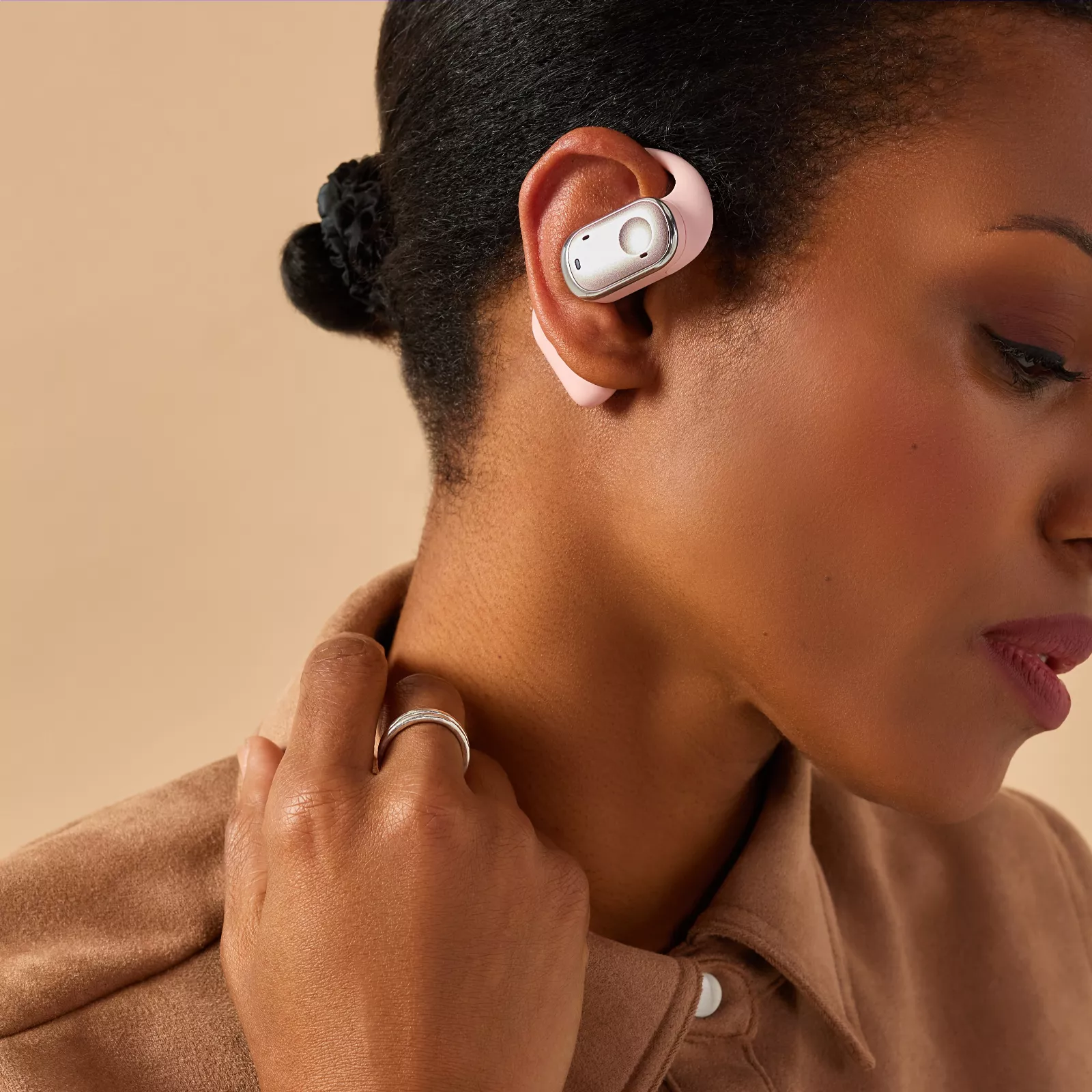 Woman wearing a pink Groovz earbud wrapped around the outside of her ear